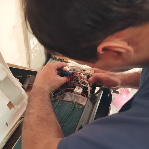 Tecnico executando reparo em unidade externa de ar condicionado